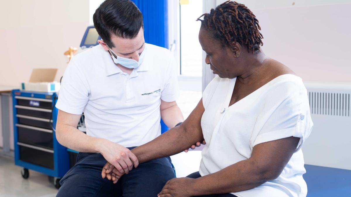 Male physio examines arm of patient