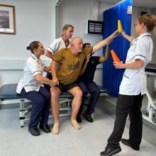 A stroke patient practices balance with a rehab team
