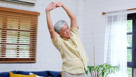 Man doing stretching exercises at home to alleviate pain