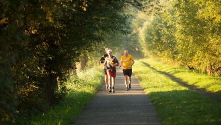 Three men running through a park