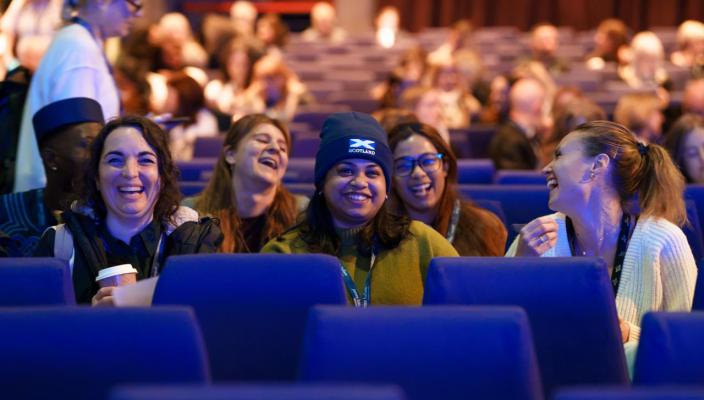 Attendees at CSP conference 2026- sitting in auditorium laughing and relaxed