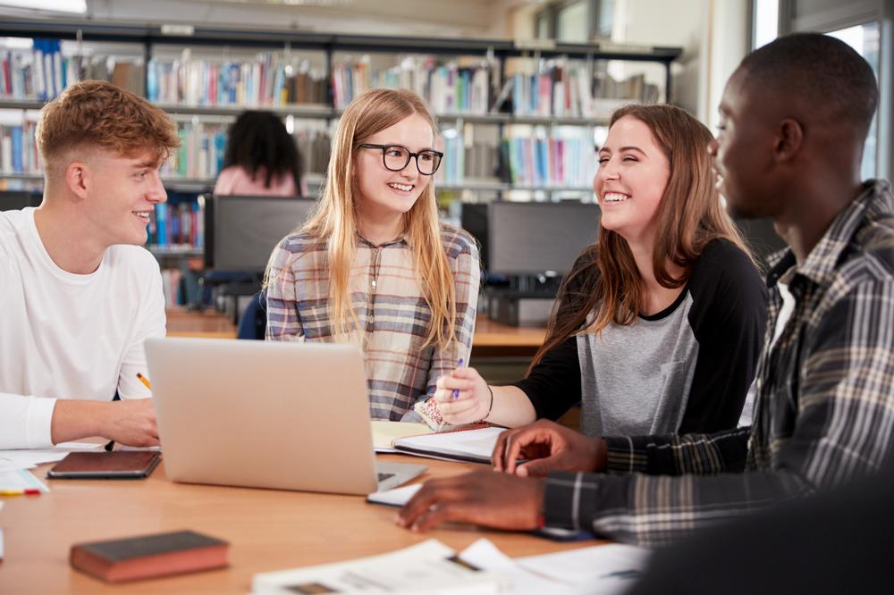 Four students work together in a library